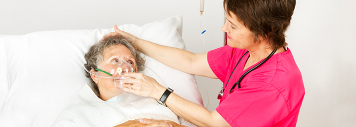 Caretaker putting oxygen mask on patient